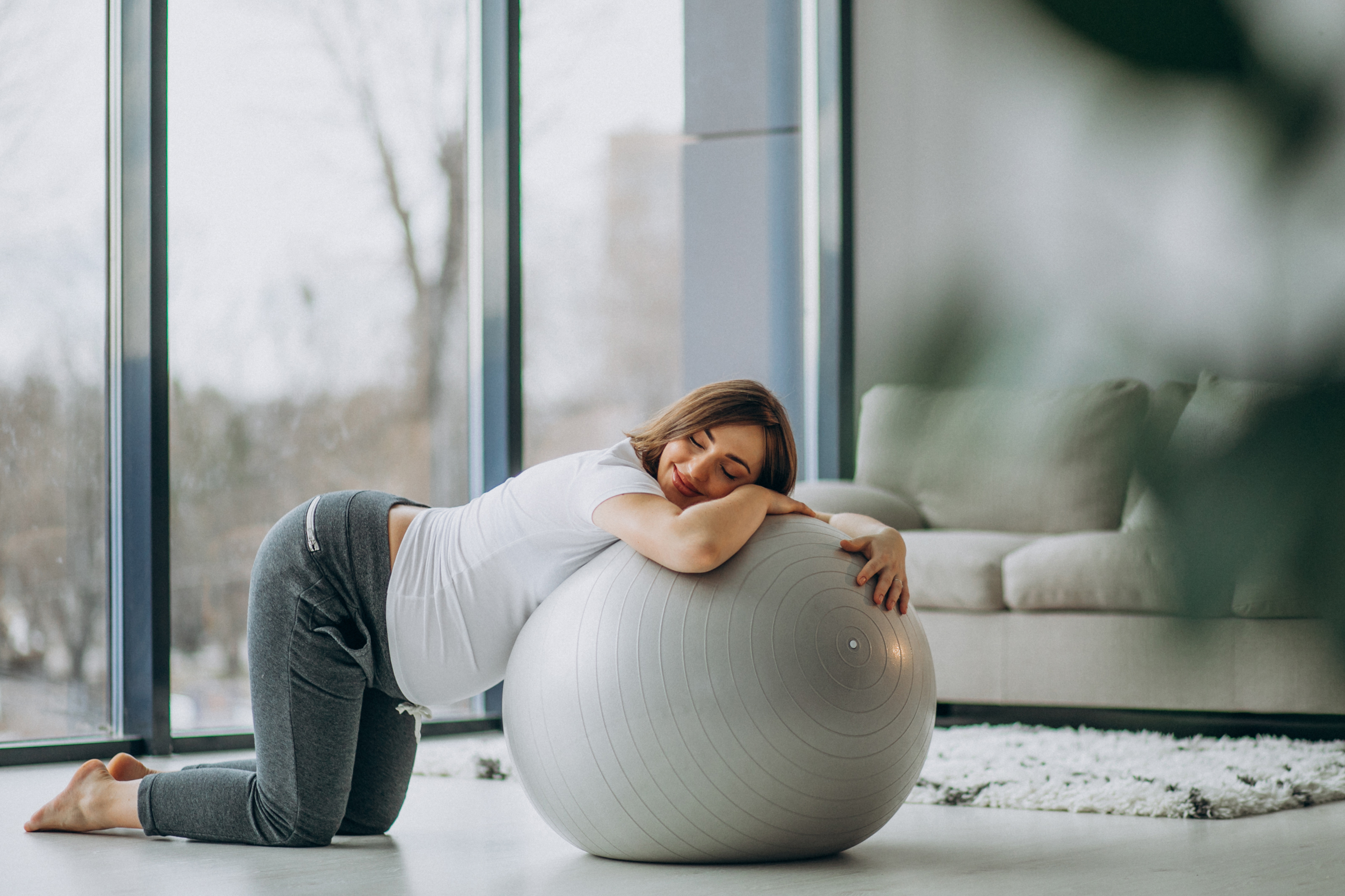 young-pregnant-woman-exercising-yoga-with-fit-ball-at-home